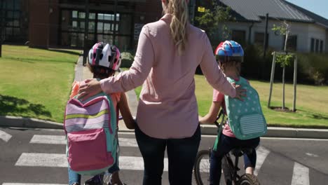 female teacher helping kids to cross the road