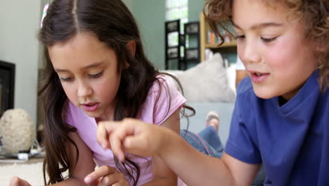 hermano y hermana usando tableta en el suelo