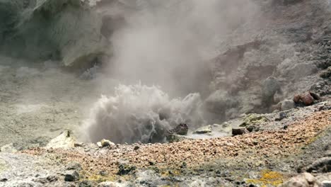 Geothermal-mud-pool-boiling-emitting-hot-steam,-White-Island