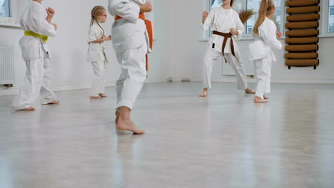 unrecognizable kids in white kimono in martial arts class