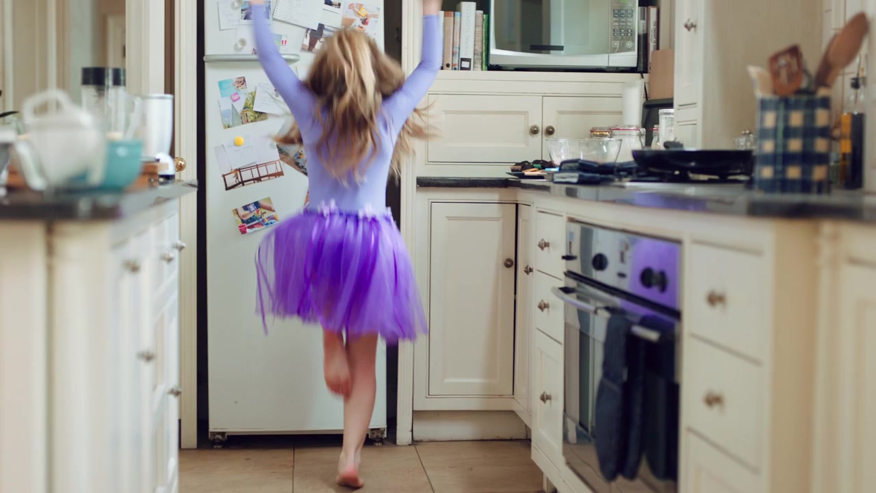 Bambina che Balla in Cucina con un Tutù Viola