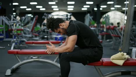 el hombre sentado y descansando después de terminar el curso de entrenamiento con pesas en el gimnasio