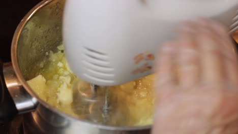 whisking warm butter and ingredients for a boiled icing recipe in a saucepan