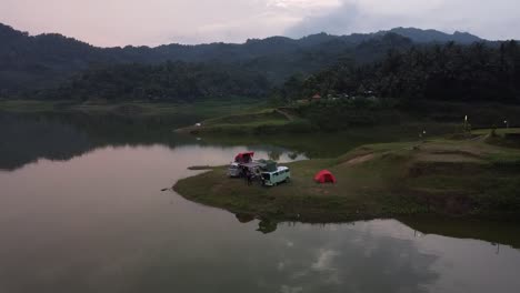 vista aérea de personas acampando cerca del lago con un hermoso ambiente matutino