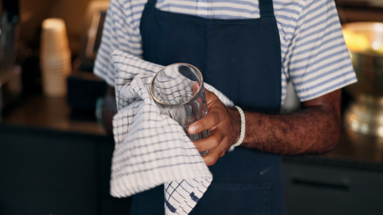 Restaurant worker cleaning a glass