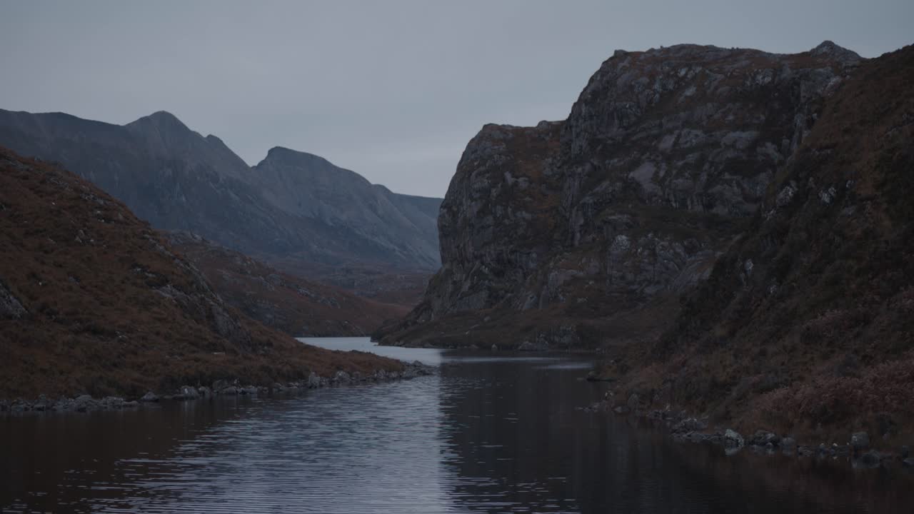 Loch na Thull nelle Highlands scozzesi. Scogliere frastagliate e cime montuose circondano acque calme, creando un paesaggio selvaggio, spettacolare e remoto, con un'atmosfera cinematografica naturale.