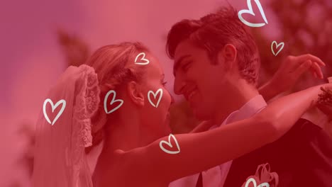 animation of white hearts over caucasian couple wearing wedding clothes and kissing