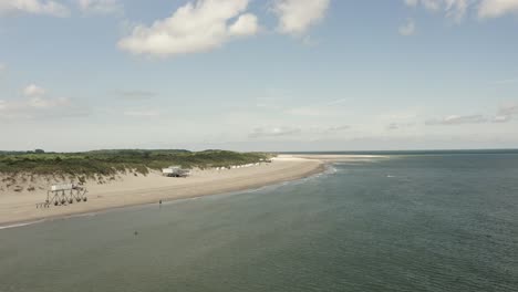 Toma-Aérea-Pasando-Por-Una-Hermosa-Playa-Blanca-Con-Marea-Alta-En-Un-Día-Soleado