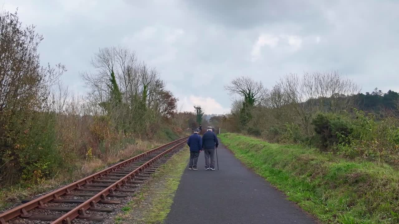 elderly gentlemen walking and talking on Waterford Greenway Ireland on a winter morning