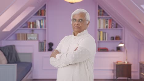 portrait of confident indian old man standing crossed hands