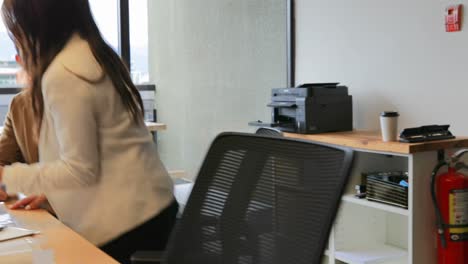 vista lateral de jóvenes empresarios asiáticos discutiendo sobre una tableta digital en una oficina moderna 4k