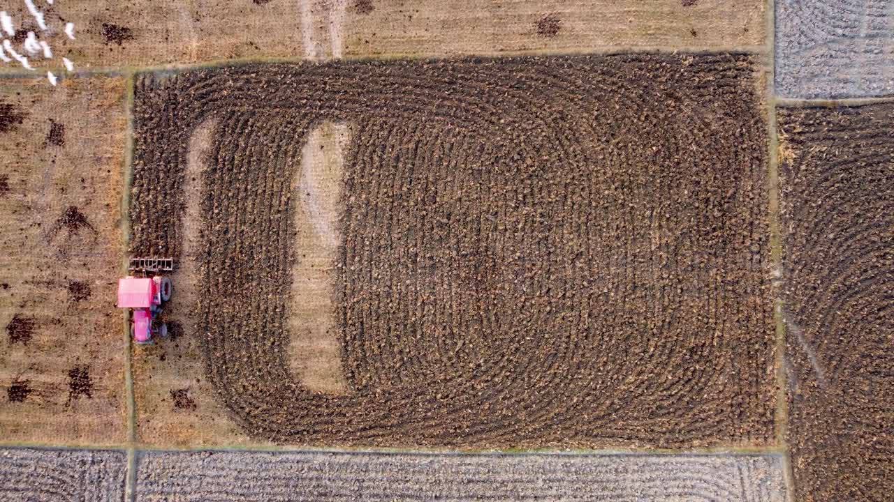 An agricultural tractor ploughing soil at large potato farm fields, West Bengal rural village farmland, Top view, Aerial