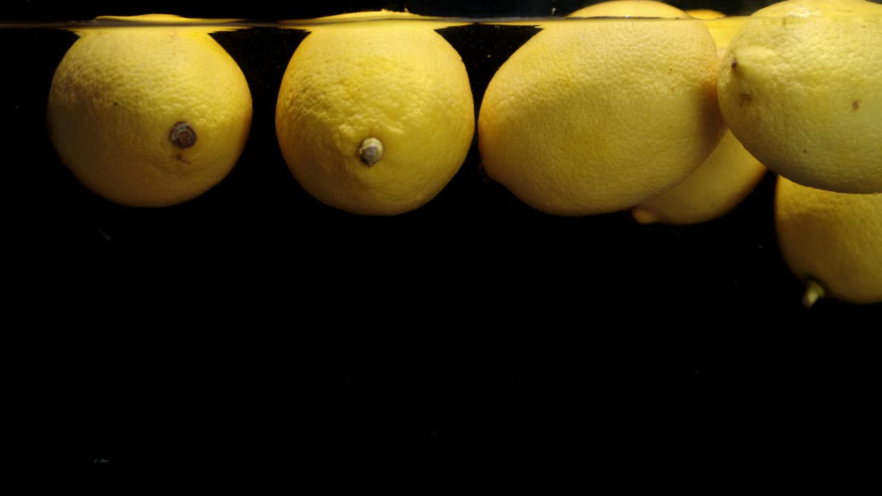 limones frescos flotando en el agua.