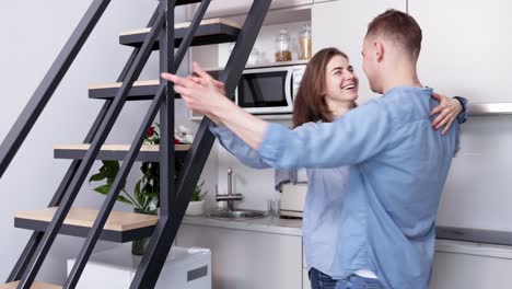 una pareja besándose y bailando en una cocina acogedora