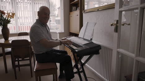 senior man playing piano at home