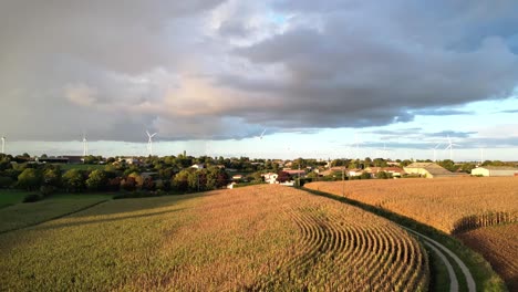 storm cloud with rain over french village with wind turbines in background