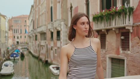 Happy-female-traveler-on-bridge-over-canal