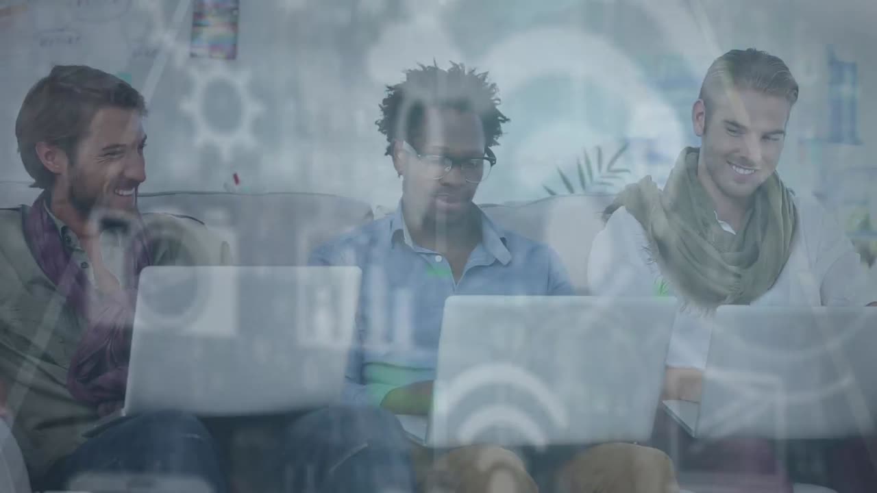 Animation of icons moving against multiracial colleagues working on laptop in modern office
