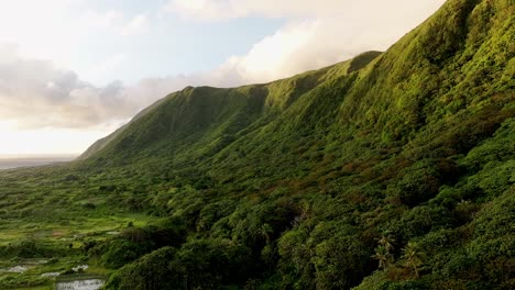 Filmische-Drohnenaufnahme-über-Einer-Grün-Bewachsenen-Insel-Mit-Bergen,-Die-In-Goldenen-Farben-Erstrahlen-–-Orchideeninsel,-Taiwan,-蘭嶼,-Lanyu