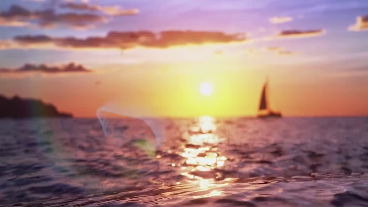 Tramonto sereno sulle onde dell'oceano con una barca a vela in lontananza, ripreso in un video con angolazione bassa