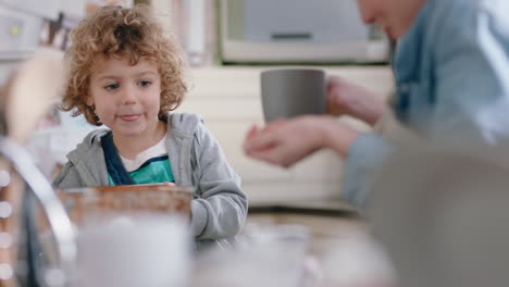 mother and son drinking hot chocolate together in kitchen happy mom caring for little boy enjoying homemade delicious beverage at home