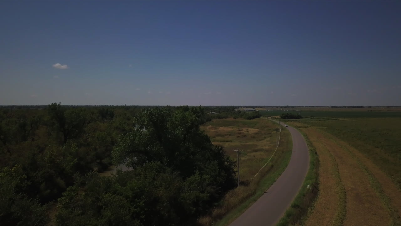 시골에서 차선을 통해 여행하는 흰색 자동차의 공중 샷