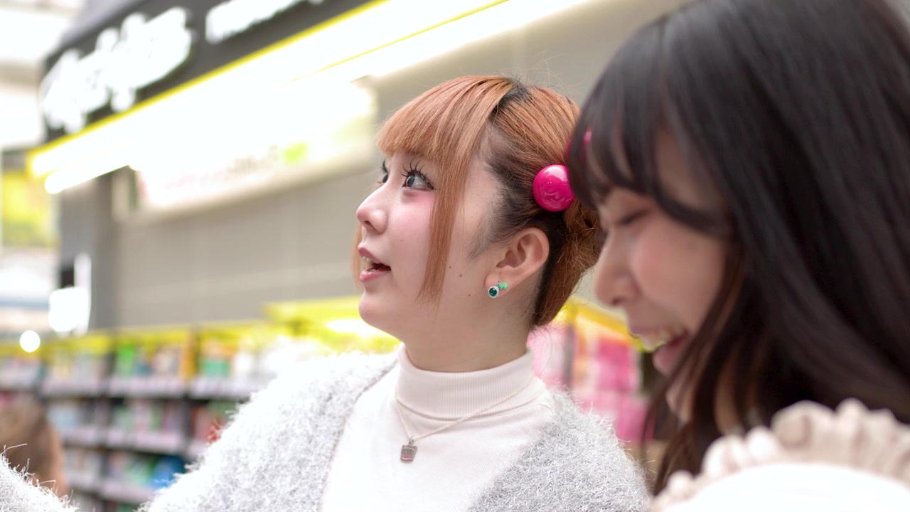 Bljje jonge Japanse vrouw die met een vriendin producten bekijkt