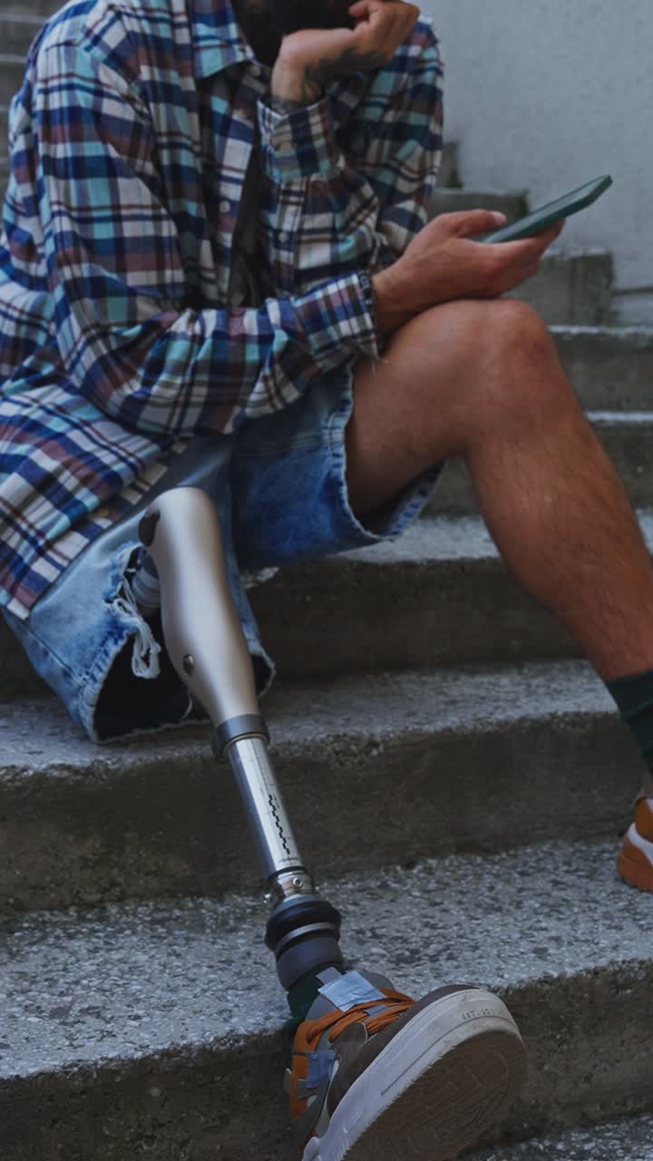 Man with Prosthetic Leg Using Smartphone on Stairs