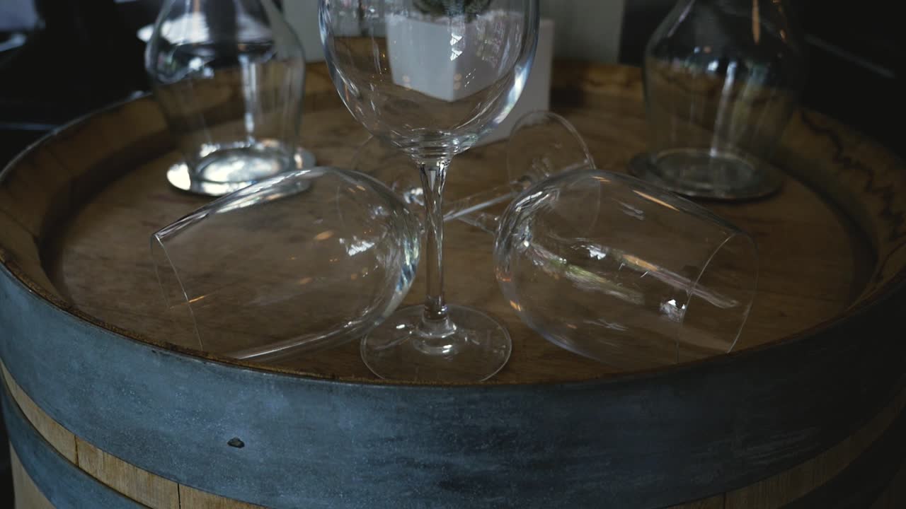 wine glasses on an oak barrel set as decoration in fine dining restaurant medium tight steady slow motion tilting up