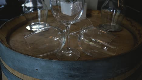 wine-glasses-on-an-oak-barrel-set-as-decoration-in-fine-dining-restaurant-medium-tight-steady-slow-motion-tilting-up