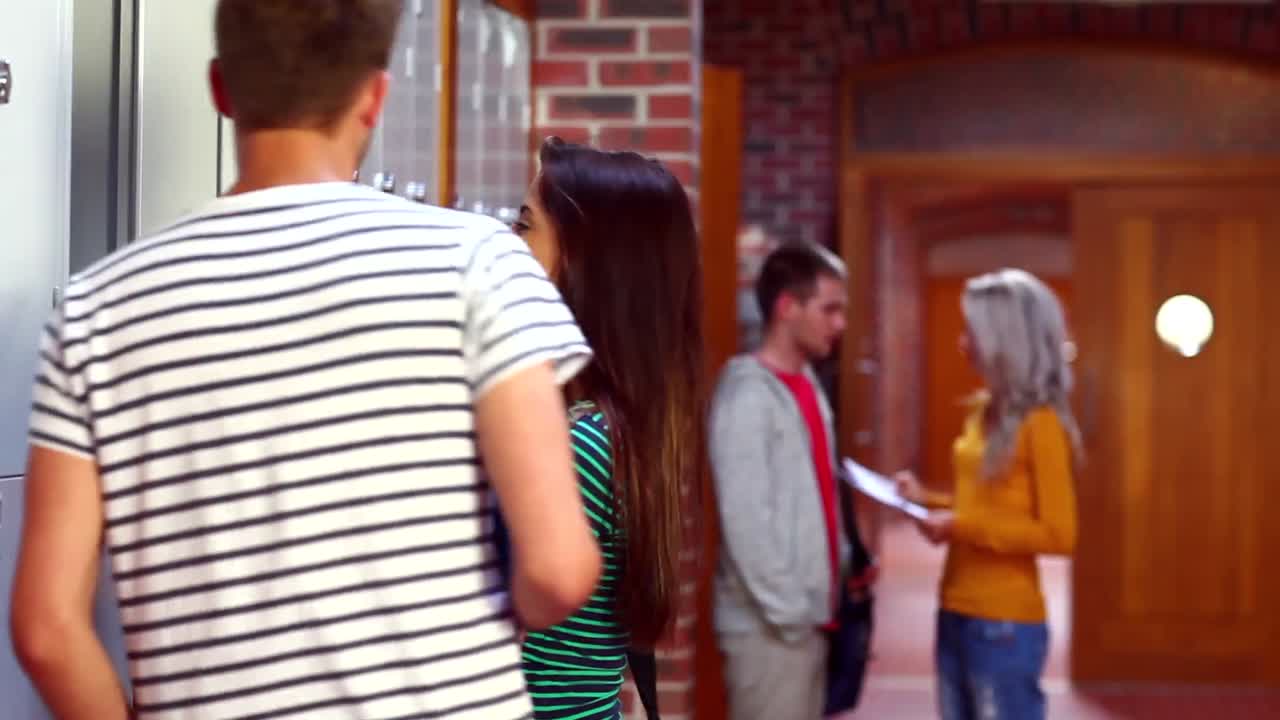 두 명의 학생들이 대화하고 복도에서  ⁇ 고 있습니다.