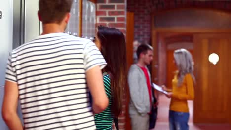 two students chatting and walking in the hallway