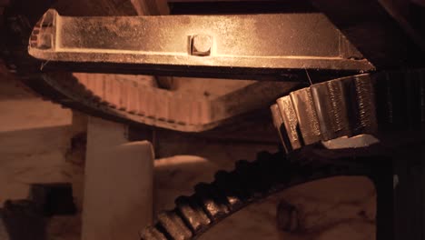 close up on a section of an interior gear mechanism of a water mill, composed by two cogwheels working together to creat movement to grind cereals into flour