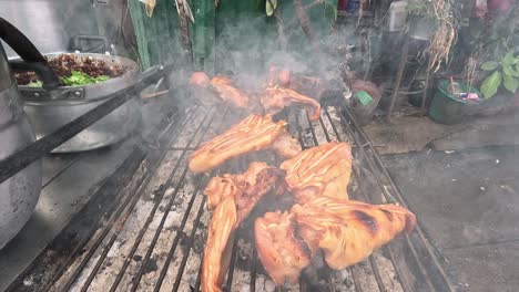 pig ears cooking on a smoky outdoor grill