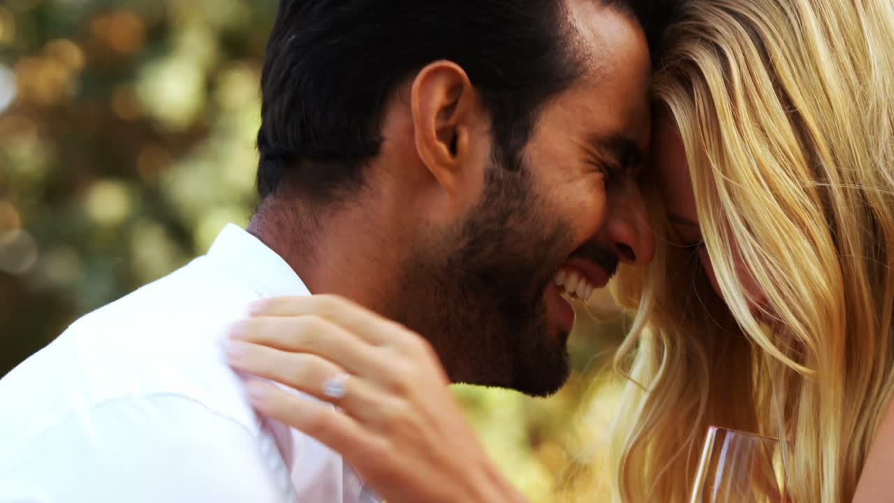 pareja romántica interactuando entre sí mientras toman champán