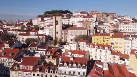 die drohne steigt an einem strahlend sonnigen tag direkt über die altstadt von lissabon, portugal, europa