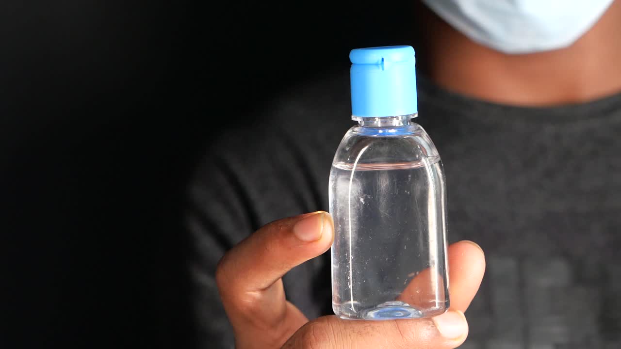 botella de desinfectante de manos en la mano