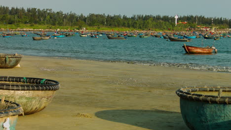 Langsamer-Dolly-Vorbei-An-Booten-Im-Sand-Mit-Booten,-Die-Im-Meer-Am-Strand-Von-Da-Nang-Schwimmen