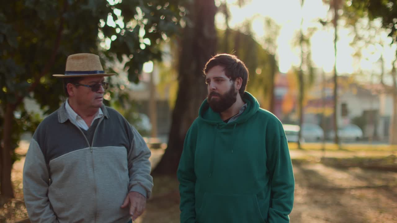 Two Men Having a Conversation While Walking Outdoors