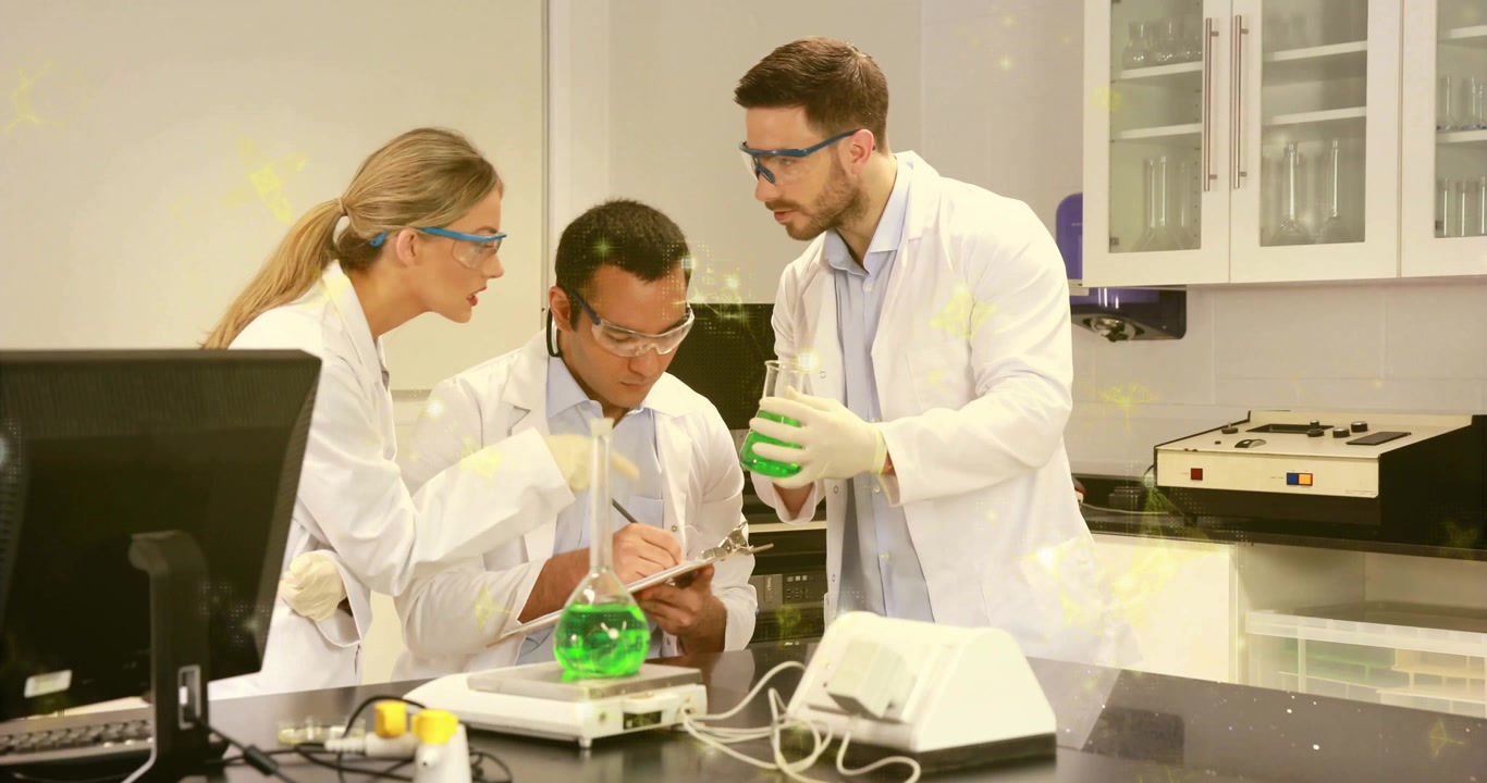 Scienziati in laboratorio, quello a destra solleva una beuta e quello al centro annota i risultati mentre quello a sinistra conferma l'accordo