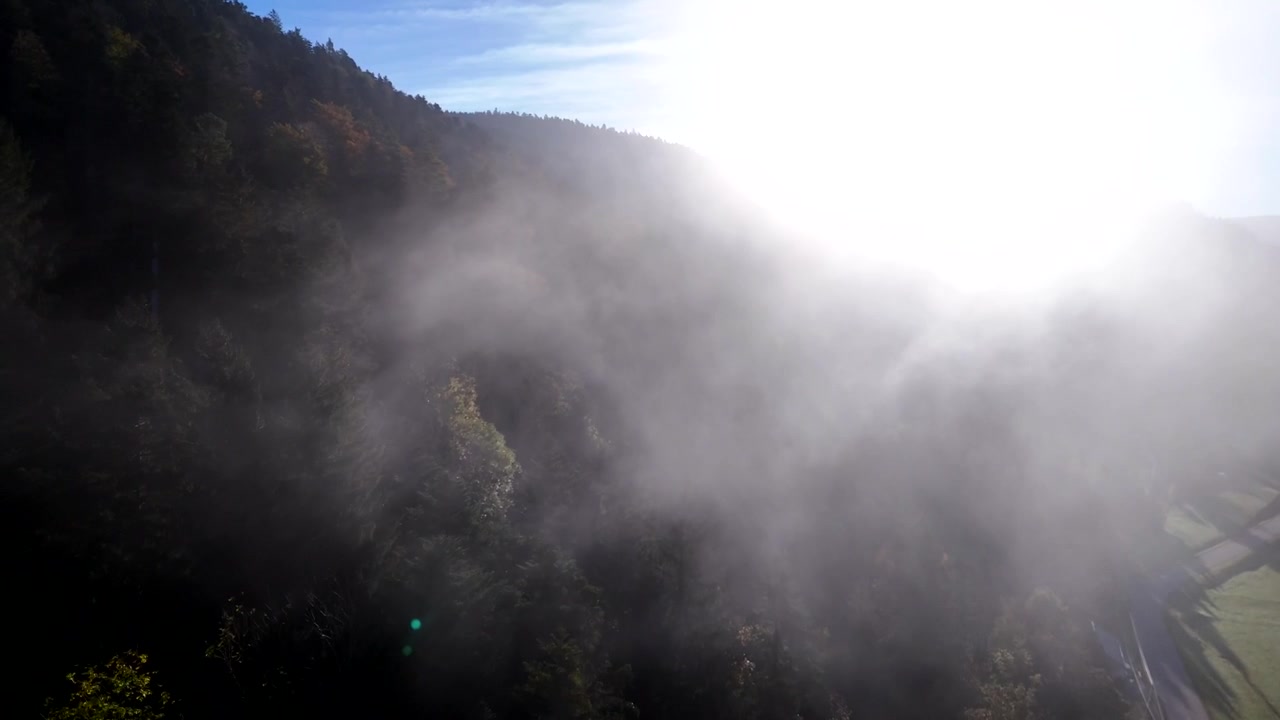 Flygvy genom moln mot solen under en höstmorgon