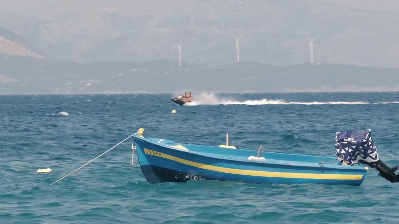Moto d'acqua che sfreccia accanto a una barca vuota che galleggia tra le onde dell'oceano