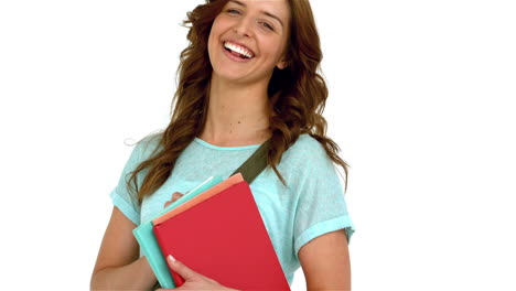 mujer sonriente con bolsa de hombro sosteniendo libros