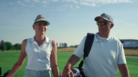 rich couple talking golf sport outside. two country club members walk on fairway