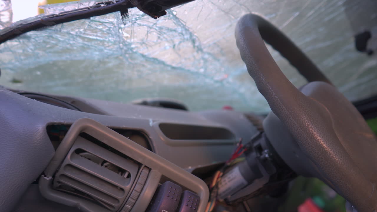 The destroyed dashboard and cracked windshields of a car after an accident