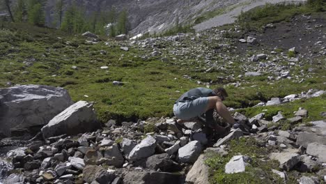 hiker drinking water from mountain stream pan tilt, rockies kananaskis alberta canada