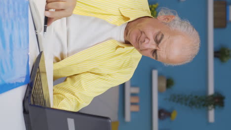 Vertical-video-of-Home-office-worker-old-man-thinking-depressed-and-feeling-unhappy.