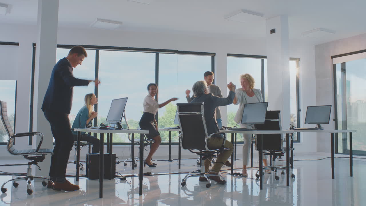 feliz equipo celebrando el éxito en la oficina moderna