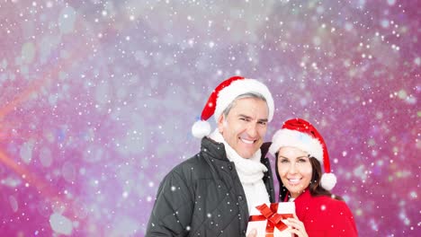 Animation-of-happy-caucasian-couple-wearing-santa-hats-over-snow-falling