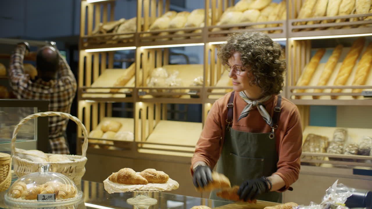 Dipendente di panetteria che prepara i croissant